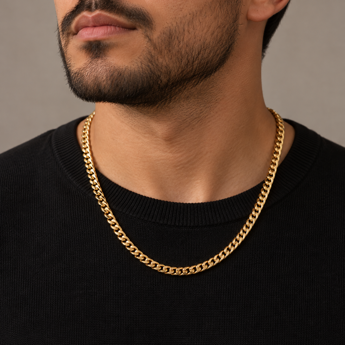 Hombre con suéter negro usando la cadena Cuban Link dorada