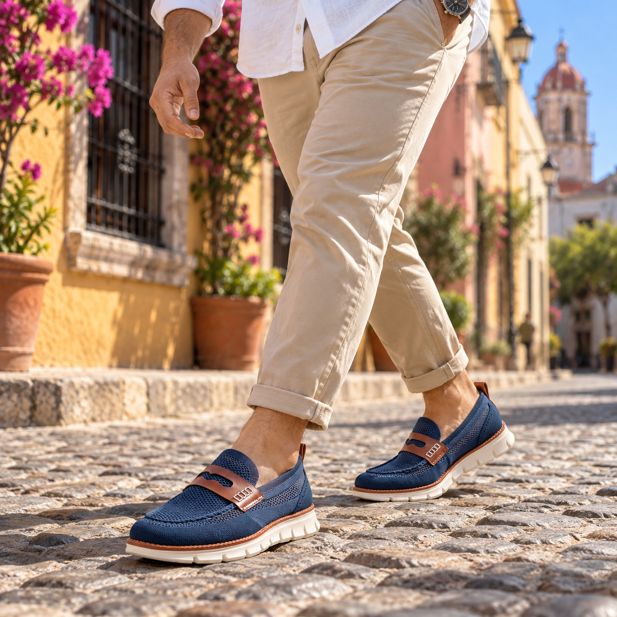 Hombre caminando con mocasines azules por una calle empedrada