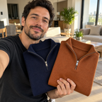 Hombre en casa mostrando los suéteres azul marino y caramelo