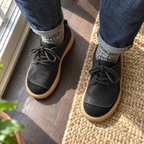 Zapatos negros puestos con jeans y calcetines grises